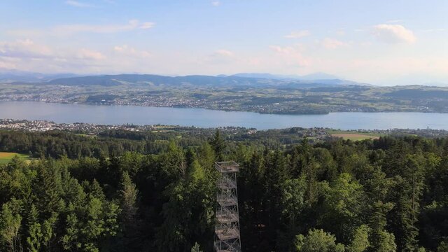 Aerial drone shot rotating around Pfannenstiel observation tower revealing lake Z&uuml;rich in the background