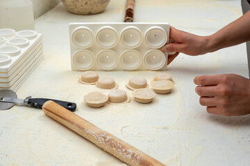 hands arranging fresh homemade sorrentino pastas in boxes for delivery on counter with flour and work items