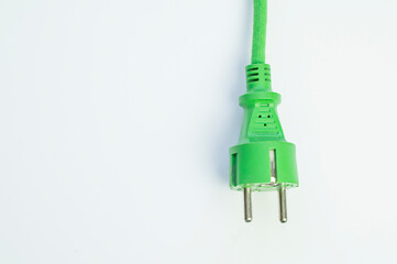 Conceptual green plug on white background, ecological green energy, copy space