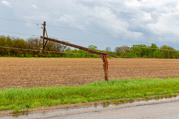 Broken electrical utility pole and power lines due to severe weather. Concept of storm damage,...