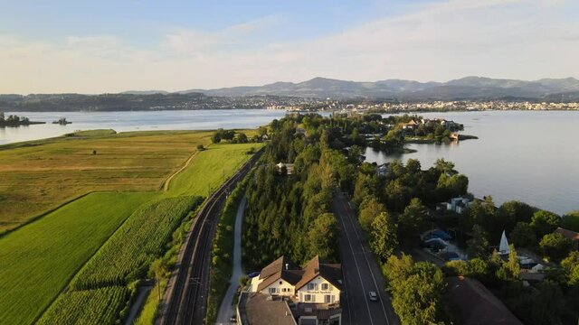 Aerial drone shot rising above Hurden overlooking Rapperswil at sunset in summer