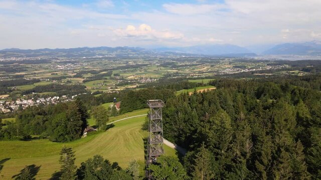 Aerial drone shot flying around the Pfannenstiel observation tower in the canton of Z&uuml;rich, Switzerland with the countyside in the background
