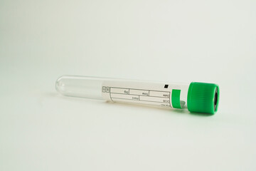 vacuum tube for collection and blood samples on white background..Transparent with green lid. Label to identify the data. Selective focus.
