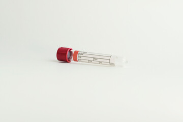 vacuum tube for collection and blood samples on white background..Transparent with red lid. Label...