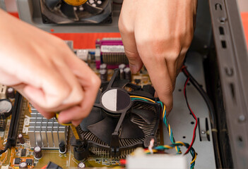 The technician assembles the CPU cooling fan after replacing the CPU.