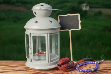 Dates fruits , beads and lantern  on old wooden table. Ramadan Concept