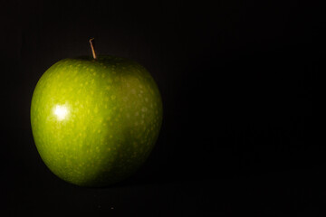 Green apple on dark background