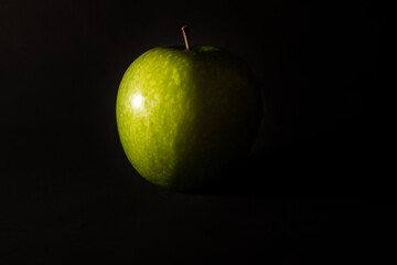 Green apple on dark background