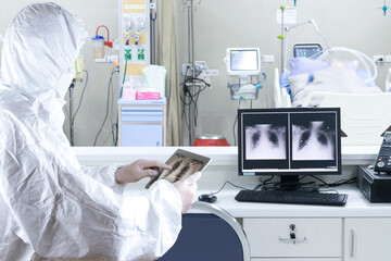 Doctor in ppe suit during coronavirus, hold a tablet to treat COVID 19