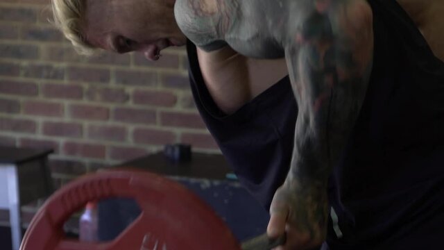 Muscly man in home gym exercising barbell row
