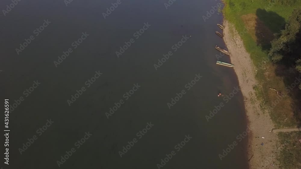 Poster An aerial view of a river with the boats on the coast with trees in HD