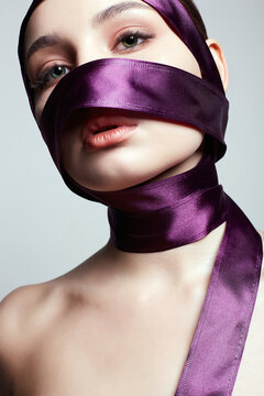 Beautiful Young Woman In Silk Ribbon On Her Face And Body