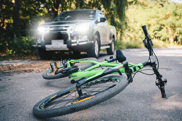 A bicycling fallen on the asphalt road after car crash accident on the road. Conceptual of accident...