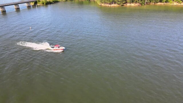 V-Hull ski boat leaving no wake zone. Drone camera follows orbits boat as it climbs and shows two boats crossing paths.