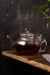 Black tea in a teapot on a dark background