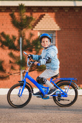 Little boy in helmet rides a bicycle on a sunny day