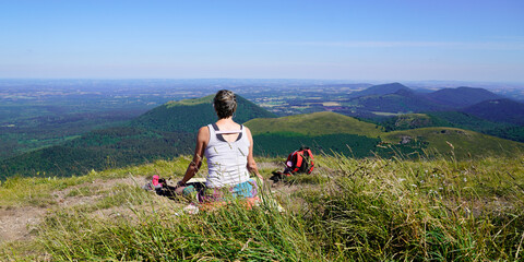 Fototapeta na wymiar sporty woman looking front of landscape natural panorama of old mountain Puy de Dome volcano in Auvergne france
