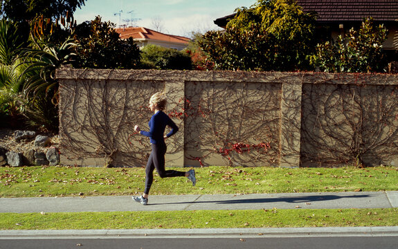 Woman running along residential street