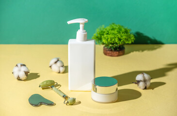 Facial care products and massagers on a yellow and green background. Concept of skin care and the use of natural organic cosmetics