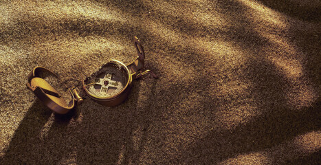 Compass laying open on rippling golden sand