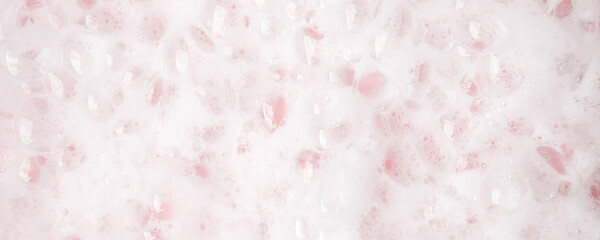 White foam bubbles texture on pink pastel background, copy space, banner for loundry, cleaning...