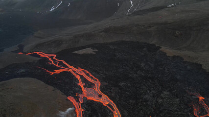 lava eruption volcano with snowy mountains, Aerial view
Hot lava and magma coming out of the crater, April 2021 

