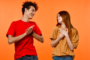 Fototapeta premium cheerful young couple lifestyle studio orange background cropped view
