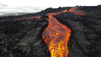 lava eruption volcano with snowy mountains, Aerial view
Hot lava and magma coming out of the crater, April 2021 
