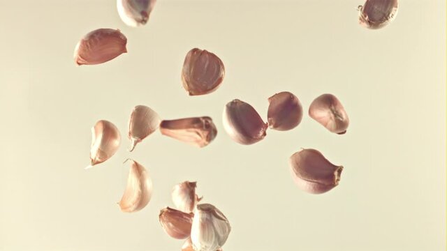 Super slow motion of the garlic falls on a gray background. Filmed on a high-speed camera, 1000 fps. High quality FullHD footage