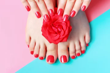 Foto op Plexiglas Vrouwelijke handen met manicure en voeten met pedicure op blauwe en roze achtergrond. © TATIANA