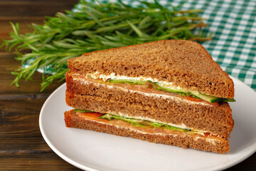 Double club sandwich served on plate on wooden table