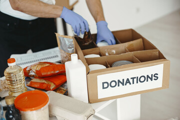 Volunteer guy packs boxes with a humanitarian help