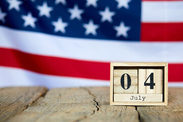 Obraz premium Wooden calendar with date on the background of the USA flag. Template for writing the dates of the national holidays of America with free text space. Independence of United State of America