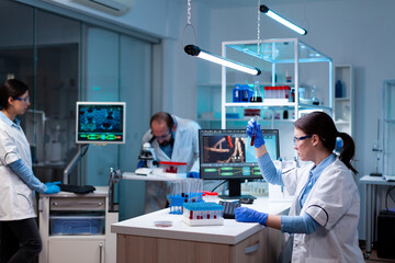 Team of scientific researchers working with professional modern equipment in laboratory. Chemists...