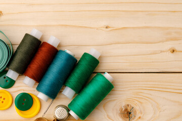 Threads and sewing accessories on wooden table