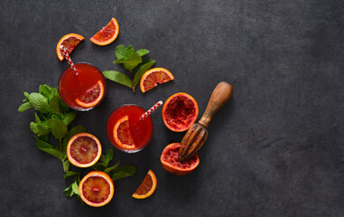 Red orange juice with mint on a black concrete background..Summer drink. Top view.