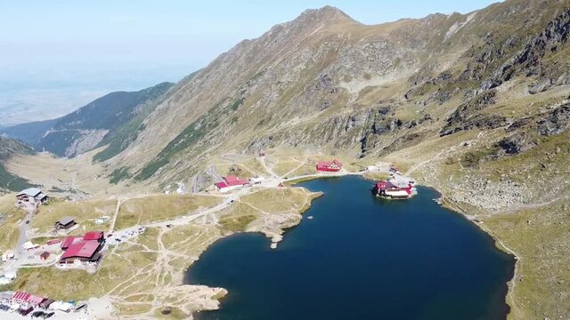 Aerial drone footage  of the Balea Lake Chalet and tourist resort in the Fagaras mountains , Transylvania , Romania.