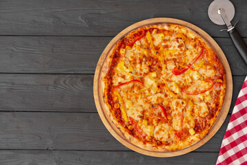 Tasty pizza on black wooden background top view