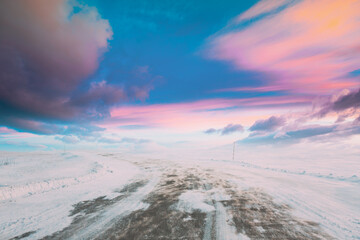 Snow-covered Open Slippy Road During A Snowstorm Blizzard In Winter. Altered Colorful Sunset Sunrise Sky. Dangerous Motion