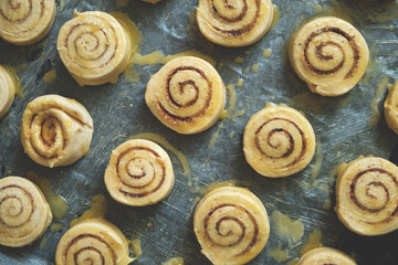 Blanks for baking cinnamon rolls on baking sheet with parchment paper.