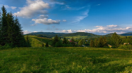Fototapeta premium Panorama of mountains on a summer day against the background of the sky with clouds