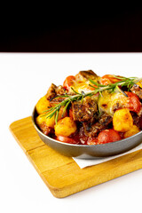 Meat with potatoes and vegetables in a frying pan