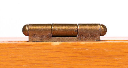 Small door hinge of gold color on a wooden box