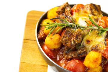 Meat with potatoes and vegetables in a frying pan