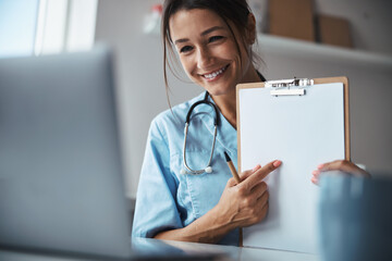 Nice female doctor giving online consultation in clinic