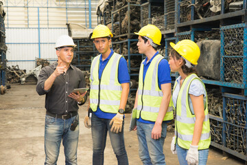 Men and woman work together, diversity of Caucasian manager explain to Asian engineer workers while someone looks at other place in factory-warehouse