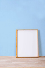 vertical wood frame mock up on wooden floor and Light blue background