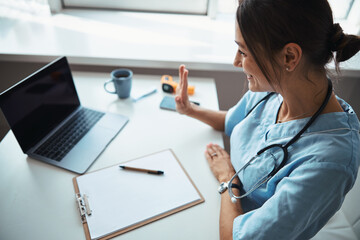 Charming female doctor using laptop in clinic © Svitlana
