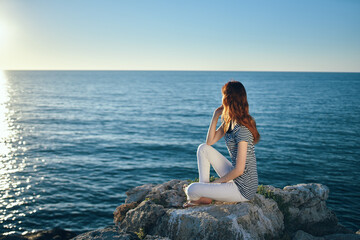 woman on the sea in the mountains in the evening at sunset high cliffs mountains