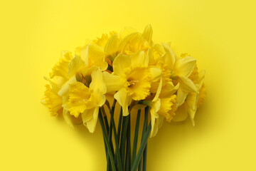 Beautiful daffodil bouquet on yellow background, top view